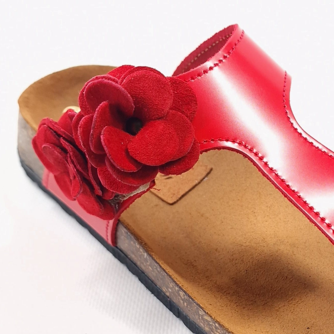 Ciabatta infradito da donna in vernice rossa con doppio fiore laterale in pelle scamosciata rossa e chiusura a velcro – Modello Ivy, handmade in Italy.
