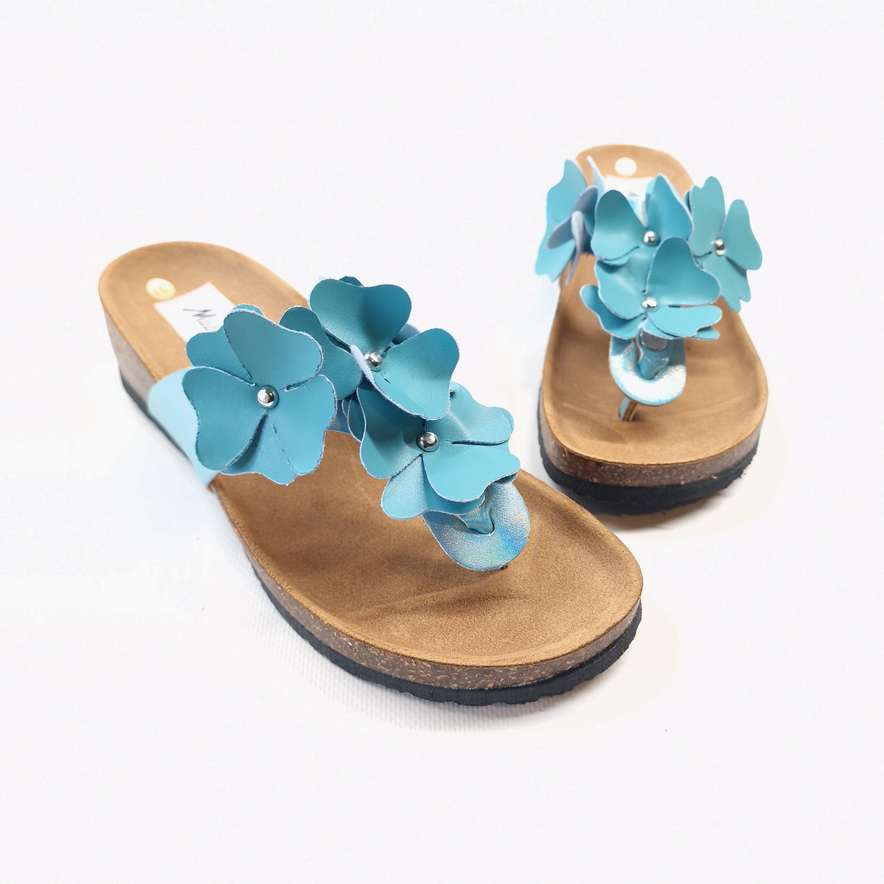Ciabatta infradito da donna in sintetico e pelle celeste con tomaia iridescente e fiori applicati con borchie modello Eloisa